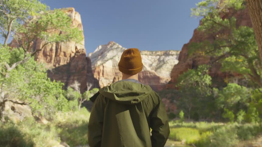 A man is hiking through a forest area