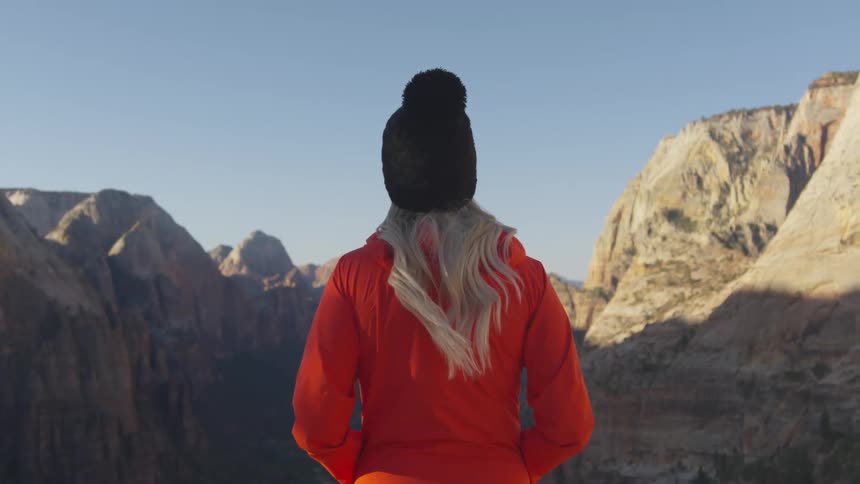 A woman is hiking near the mountains