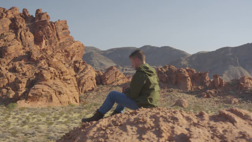 A man is sitting on the mountain