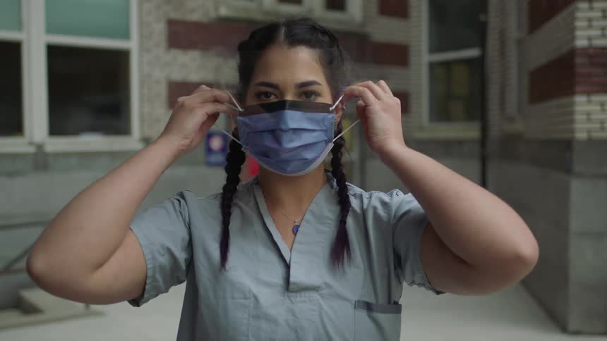 Brunette female demonstrates how to wear a protective mask