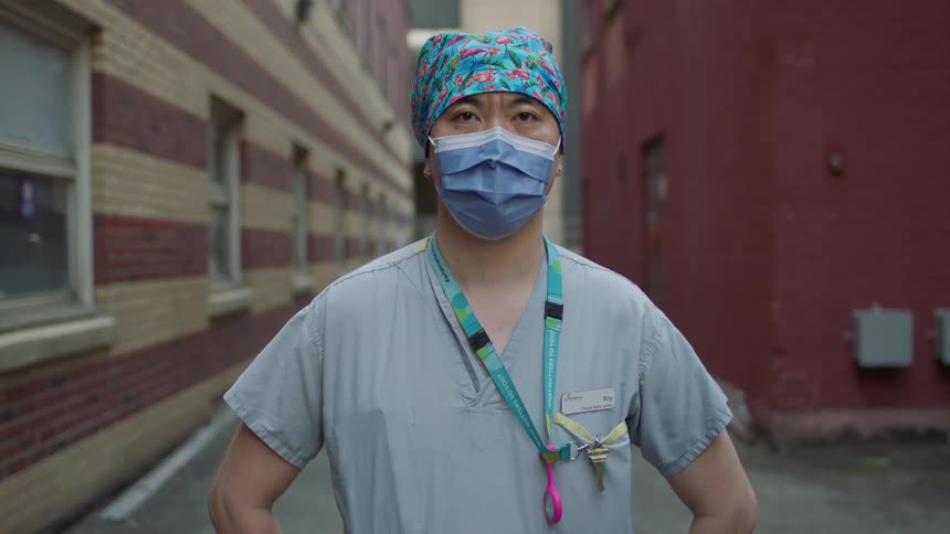 A doctor stands outside a hospital