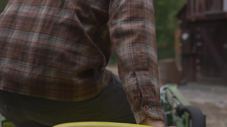A young man climbs in to a tractor
