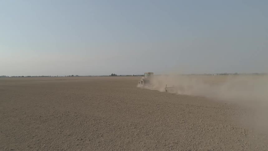 A tractor plowing a rural dirt field