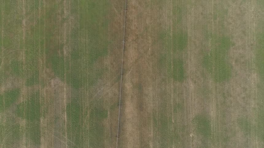 Aerial top down view of a field with patches of green grass