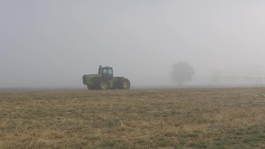 A tractor sitting in a field on a farm