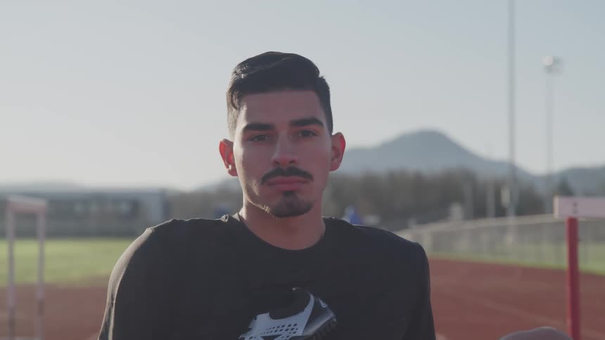 A man stands on a track and field