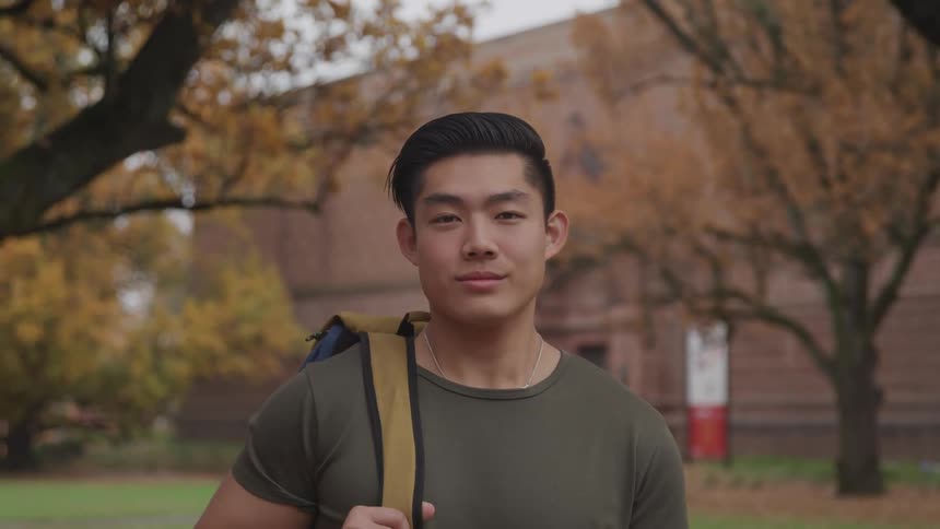 Young man with backpack on college campus in fall