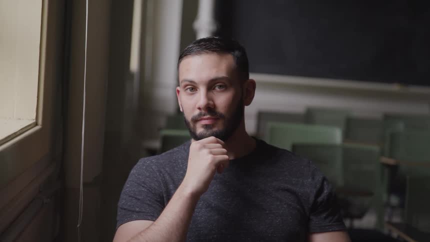 A man sitting in an empty classroom