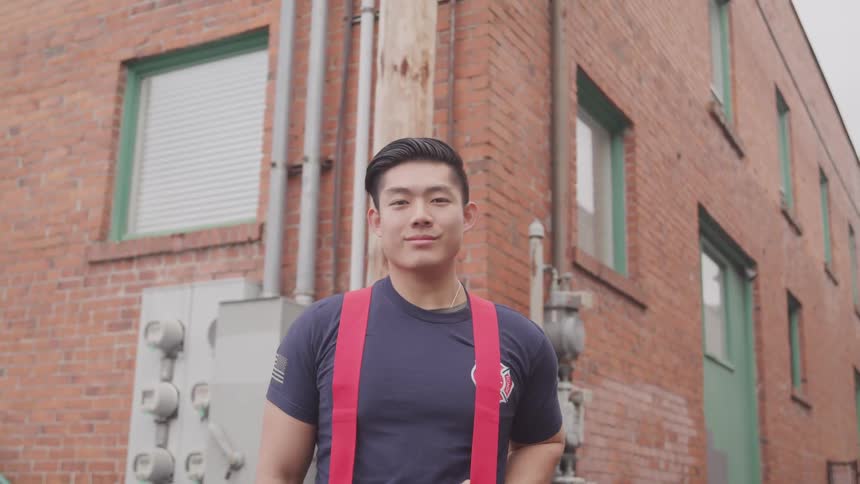 A firefighter is standing outside of a building