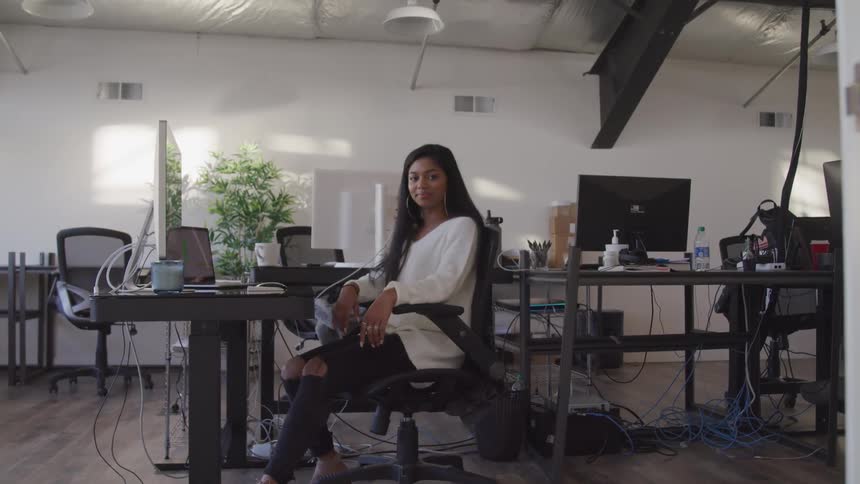 Young woman sitting at a desk in the office looking at the camera