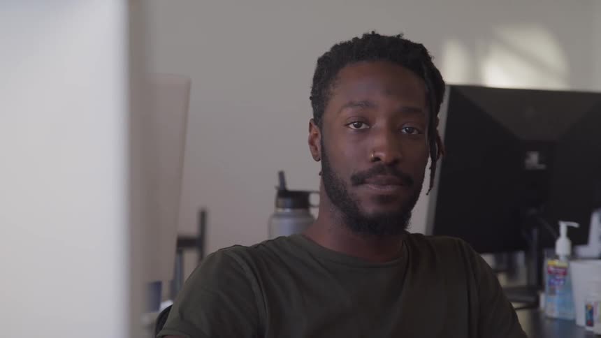 Young bearded man looking at the camera while sitting in the office