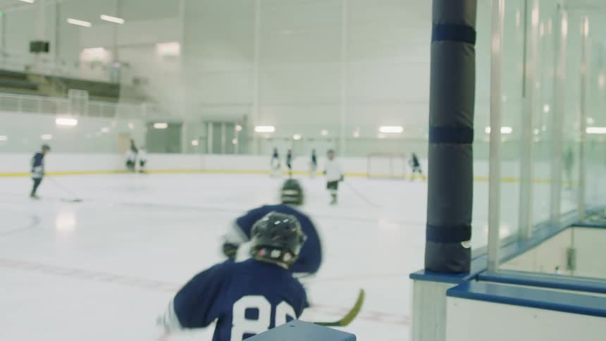 Team of boys practice hockey in a stadium