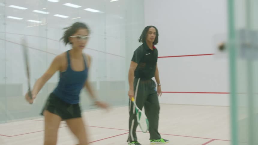 Two people play indoor raquet ball