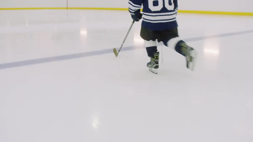 Child in hockey uniform skates across ice rink