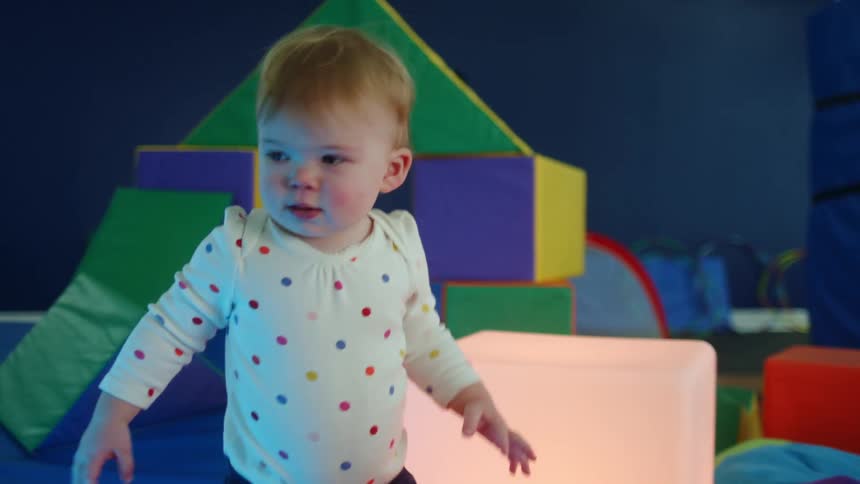 Baby playing with large foam blocks in gym