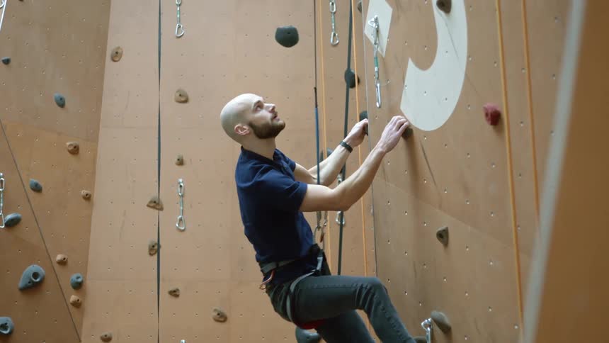 A young man rock climbing on a wall
