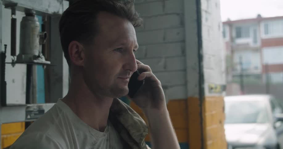 Man talking on cell phone in alley