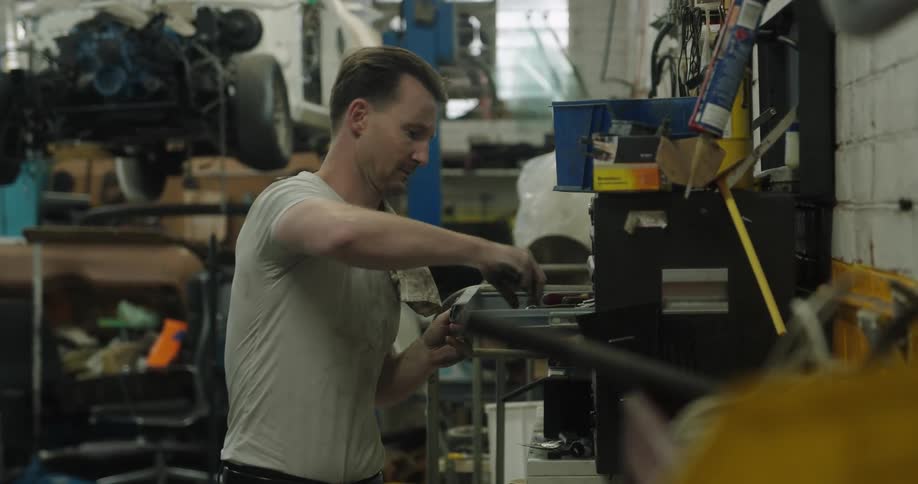 A mechanic gets tools out of a tool box