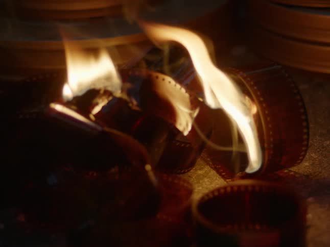 Rolls of film out of their cans burning on the ground at night
