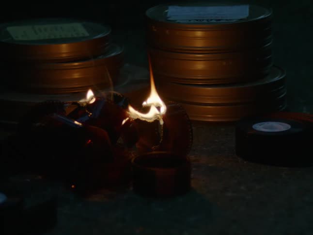 A fire burning next to some metal tins