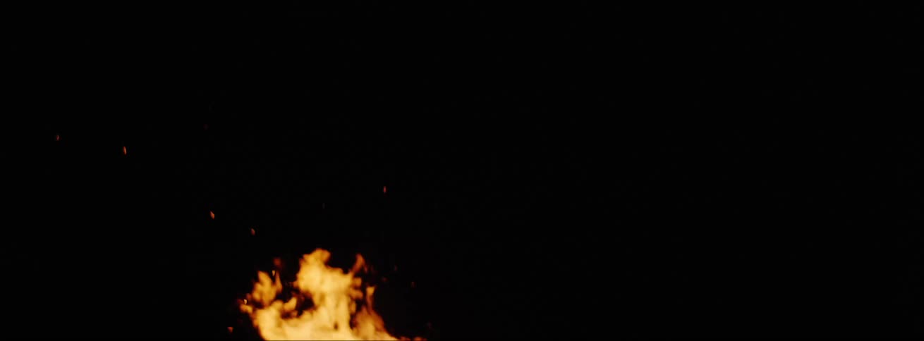 A bonfire with flames light and embers with logs burning