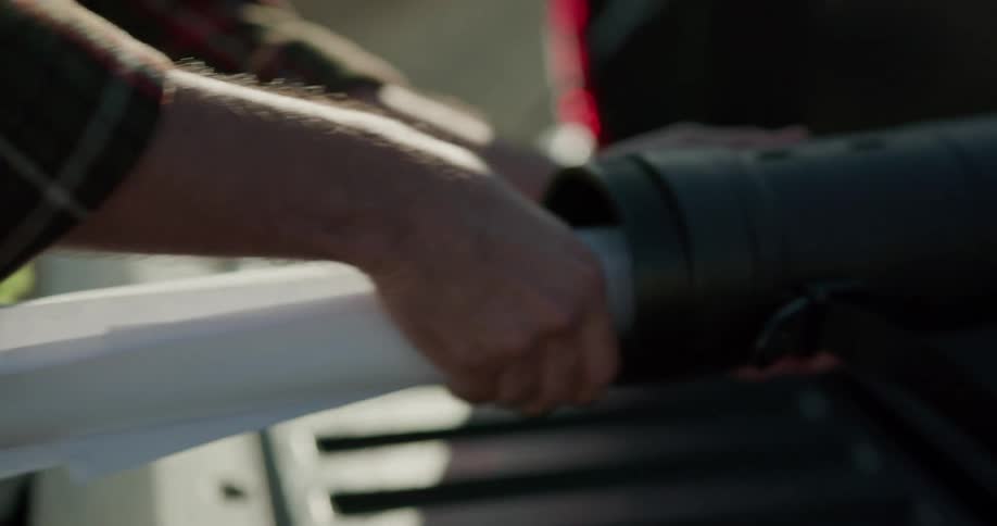 An employee on a wind farm rolls up a blue print and puts it in a tube