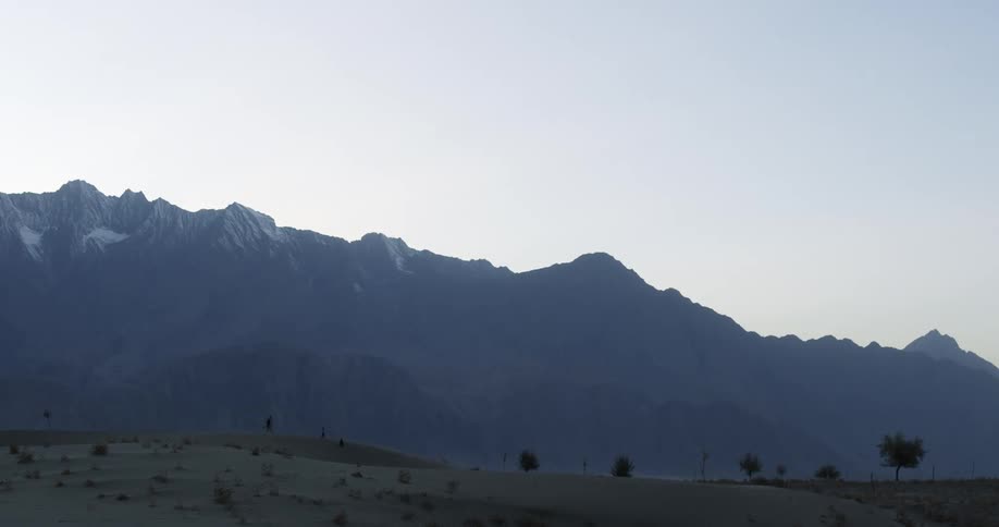 Landscape view of a grassland in front of a mountain range