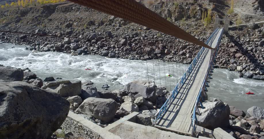 Multiple people use floatation items on a rough river