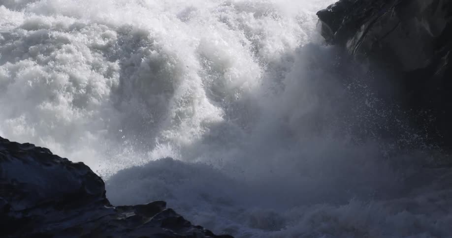 Turbulent waters of a rivers rapids splashing on the rocks