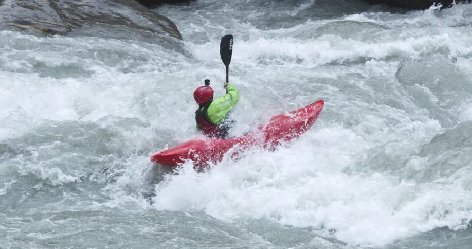 A person kayaking through river rapids