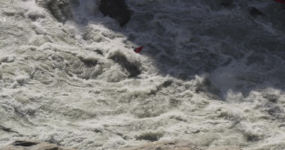 A person kayaking through river rapids