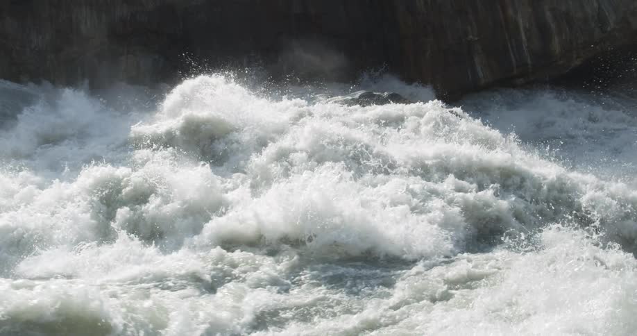 A river flowing with water and mist with rocks in the background