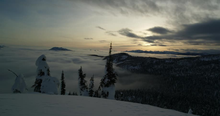 Clouds floating over a snowy mountain landscape