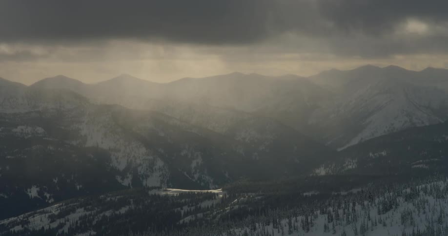 Snow covered mountain range under heavy cloud cover