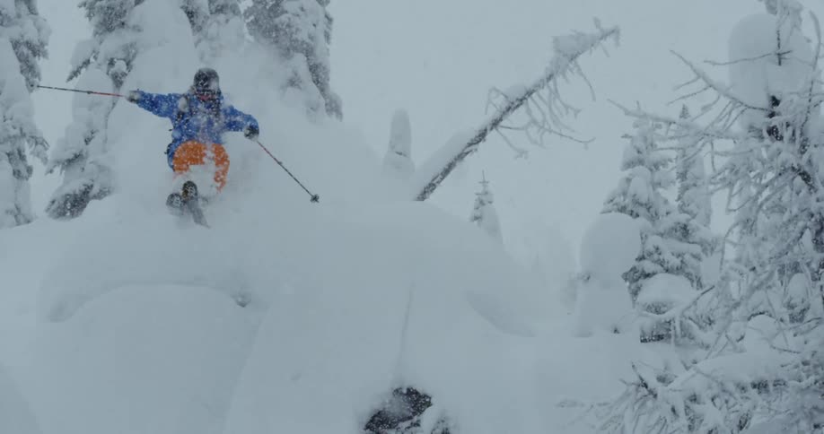 A skier skiing down a snowy slope