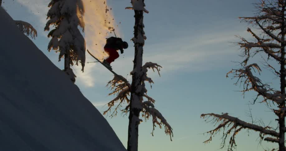 A person jumps as they ski down a mountain