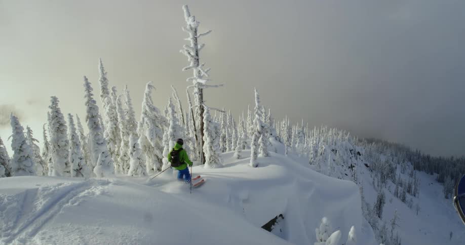 A skier skiing down a snowy mountain slope
