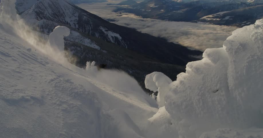 Downhill skier on steep slope in mountains