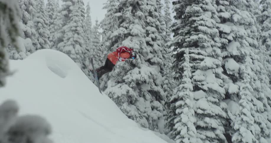 Person does flip over ski jump in snow covered forest