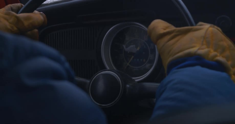 A man's gloved hands on a steering wheel