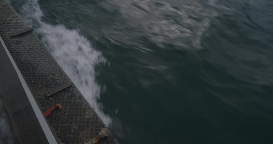A boat in the ocean moving forward and splashing water