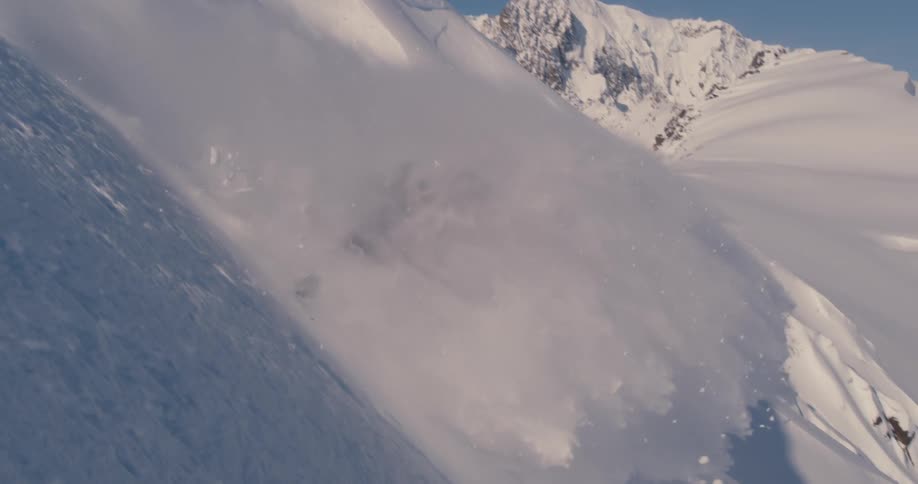 Person snowboarding on steep mountainside
