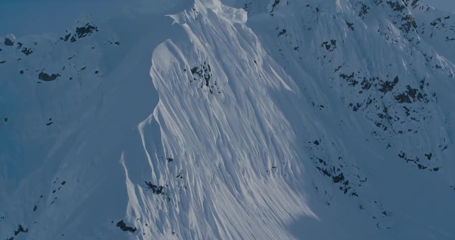Snow covered peaks of a mountain range under a blue sky