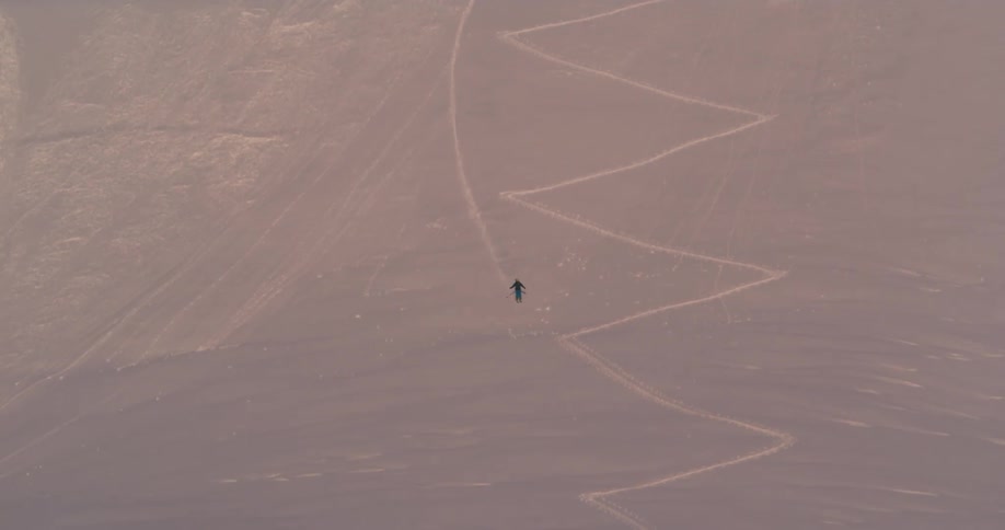 A skier descends a mountain slope in the evening