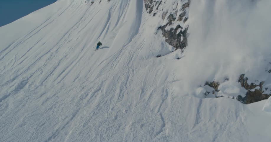 Person skiing down steep mountainside