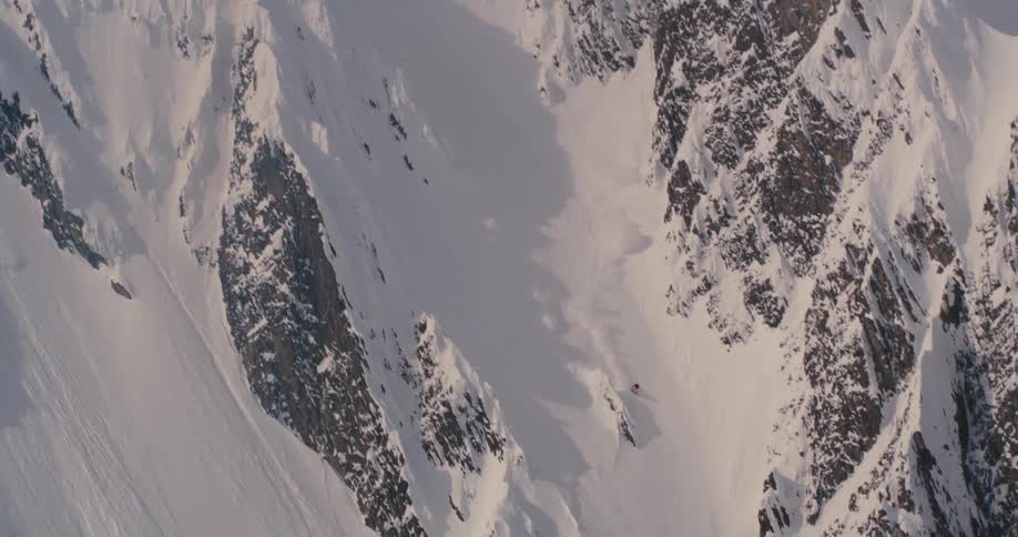 Person skis down steep mountainside