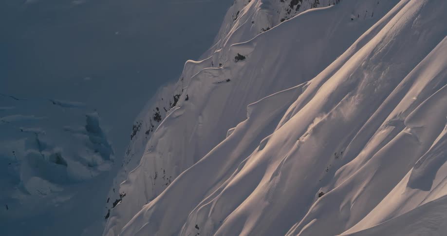 Skier rides down steep mountain slope