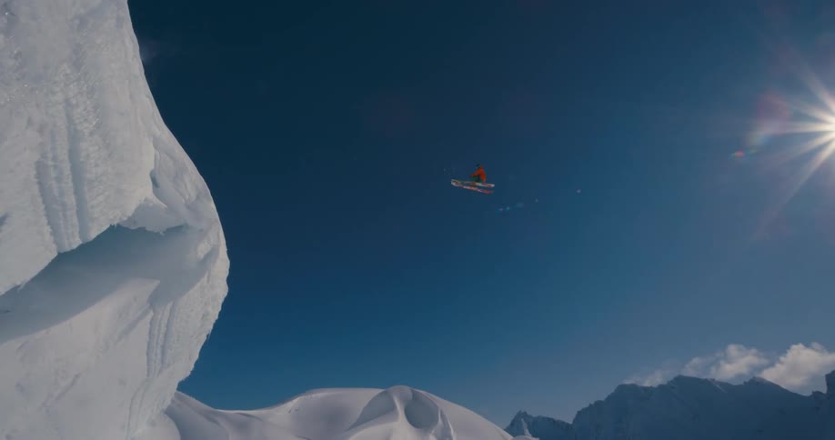 Skier takes extreme high jump off of cliff into snow