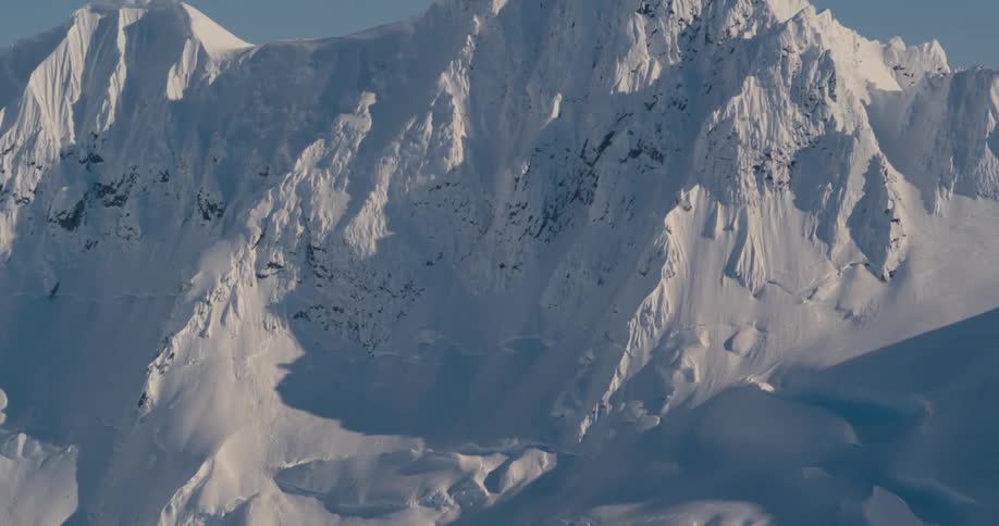 Snow covers a tall mountain in the wilderness
