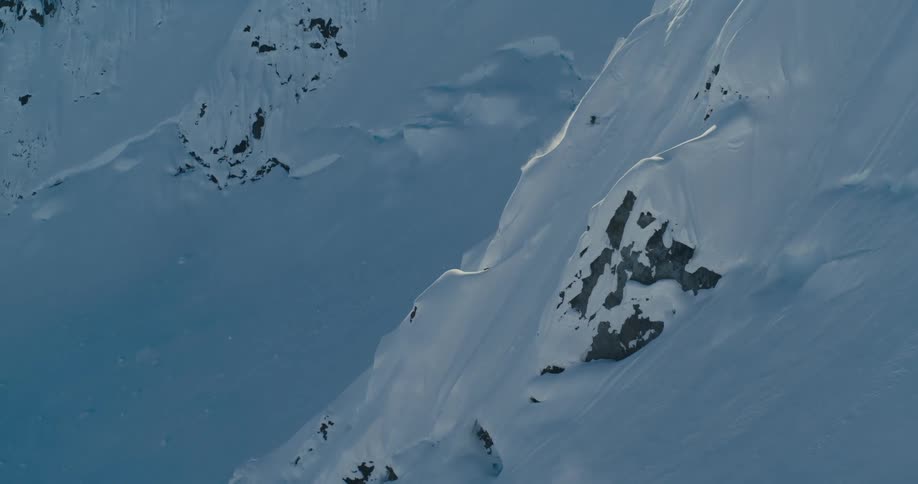 Person skis down steep mountainside